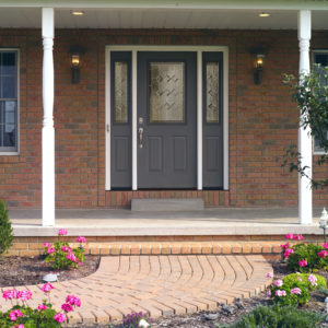 Brick home with a paved pathway leading to a blue front entry door