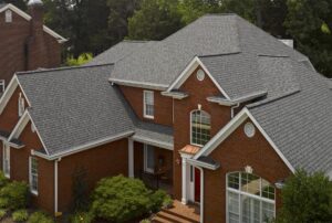Top-down view of a large brick home with an asphalt shingle roof