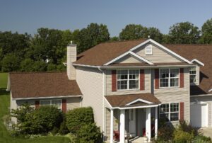 Suburban home with brown asphalt shingles and red shutters